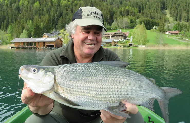 Angler hält einen großen Süßwasserfisch in beiden Händen.